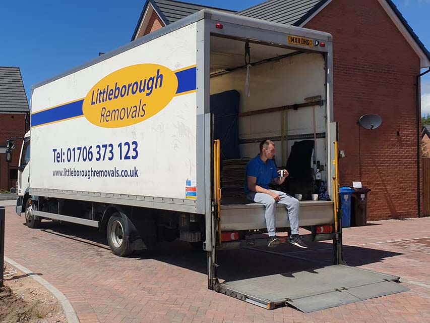 man in back of Littleborough Removals van having a cup of tea